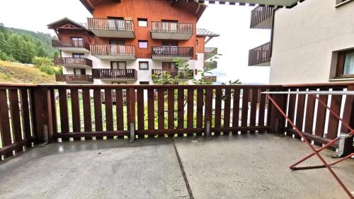 - un balcon avec une clôture en bois et un bâtiment dans l'établissement Résidence Parc Aux Etoiles - GEB12 - APPARTEMENT 2 CHAMBRES ET TERRASSE MAE-7331, à Narreyroux