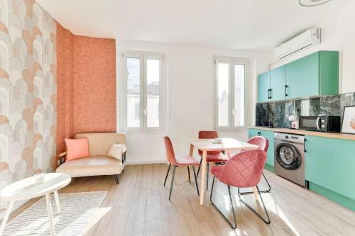 une cuisine avec une table et des chaises dans une pièce dans l'établissement Élégant appartement - centre Prado Vélodrome, à Marseille