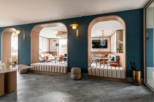 a living room with two mirrors and a dining room at Visionair Suites & SPA-Room Only e Honesty Bar in Senigallia
