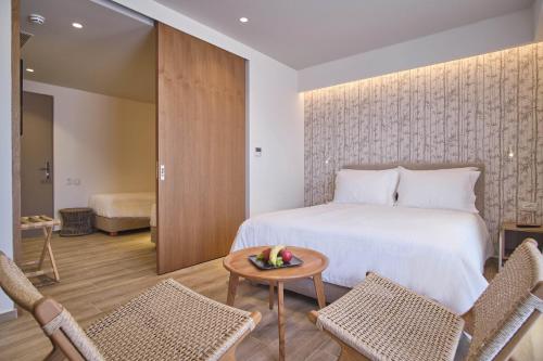 a bedroom with a bed and two chairs and a table at Utopia Blu Hotel in Tigaki