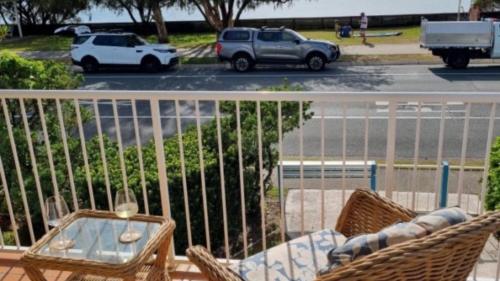 a balcony with a table and chairs and a parking lot at #1 Seascape, Golden Beach Waterfront Location in Golden Beach