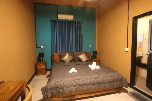 a bedroom with a bed with two swans on it at Bat Chum Villa in Phnom Penh