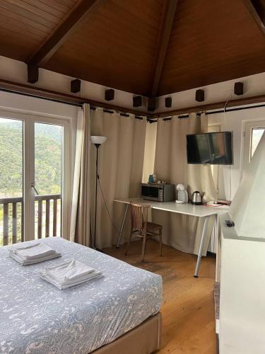 a bedroom with a bed and a table and a television at Casa les Pomeretes in El Figaró