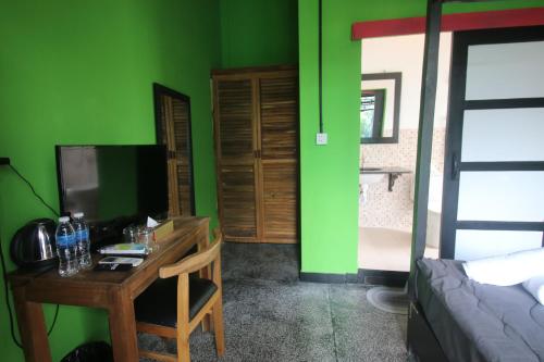 a room with a desk and a green wall at Bat Chum Villa in Phnom Penh