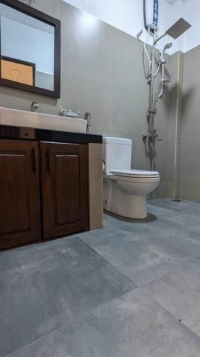 a bathroom with a toilet and a sink and a mirror at Mayon Beach villa in Tangalle