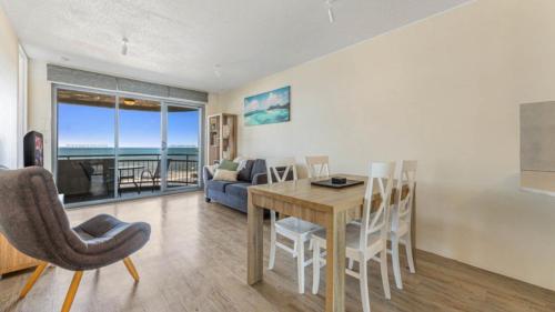 a dining room and living room with a table and chairs at #6 Seaspray, Kings Beach - Absolute Waterfront in Caloundra