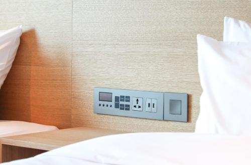 a clock on a wall next to a bed at Haenam 126 Hotel in Haenam