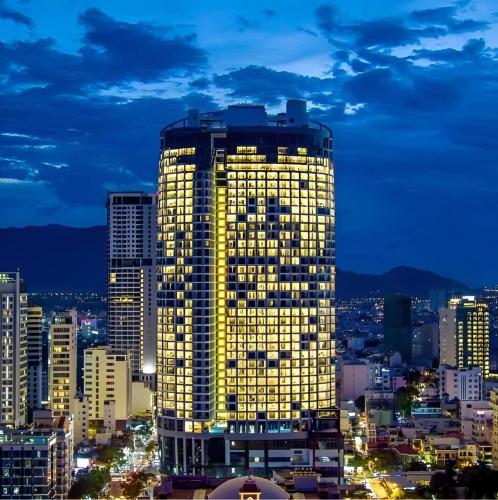 a lit up building in a city at night at Panorama Nha Trang Condotel by One in Nha Trang
