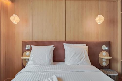 a bedroom with a bed with white sheets and pillows at Aparthotel AMMI Nice Lafayette in Nice