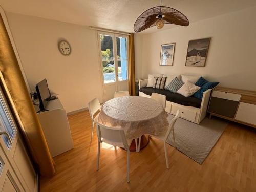 un salon avec une table et un canapé dans l'établissement Charmant T2bis, belle vue centre, à Cauterets