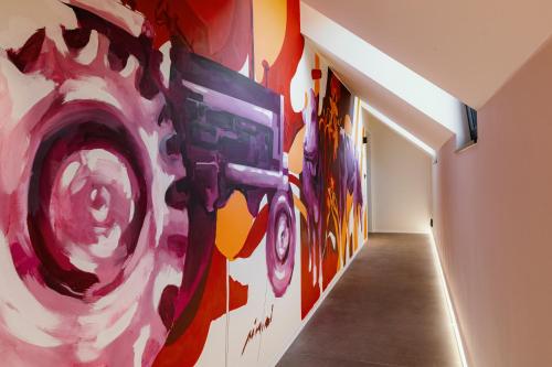 a hallway with colorful paintings on the walls at CC Nomie Hôtel Restaurant in Dinant