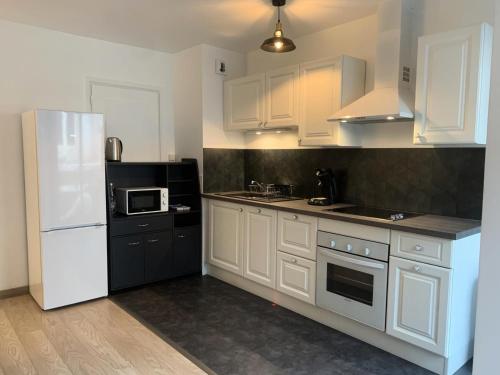 une cuisine avec des armoires blanches et un réfrigérateur blanc dans l'établissement Résidence Le Chateau Durieux 1 - Très cosy et chaleureux 2 pièces MAE-7941, à Aix-les-Bains