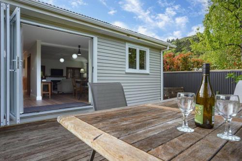a wooden table with a bottle of wine on a deck at Morgan's Treasure in Hanmer Springs
