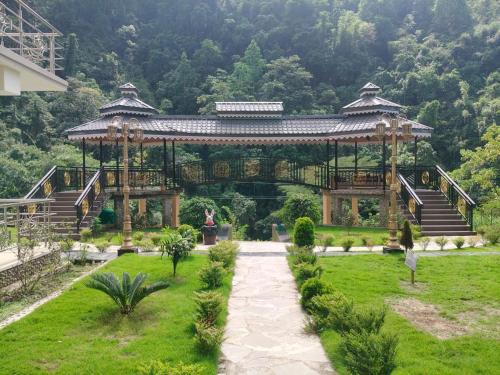 a gazebo in a park with a person in it at Nature's Nest Resort in Rongli