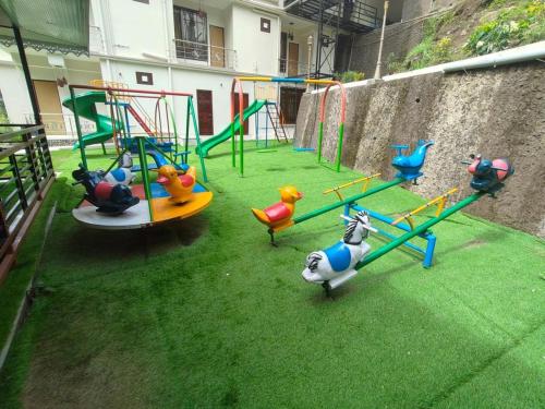 a playground with different kinds of play equipment on the grass at Nature's Nest Resort in Rongli