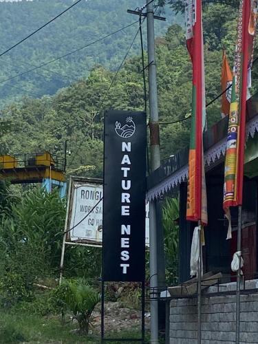 a sign for a hotel on the side of a building at Nature's Nest Resort in Rongli