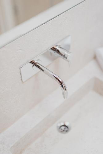 a bathroom sink with a chrome water faucet at Relais Corte Guastalla Apartments in Sona