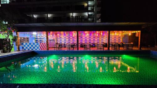 a swimming pool with green lights in a building at Vang Vieng Sabai Sabai Hostel in Vang Vieng