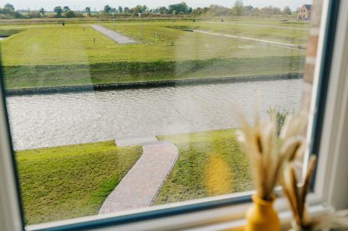 a window with a view of a body of water at Küsten Suite Grachten Suite 2 direkte Wasserlage, Terrasse, 76qm, Neubaugebiet in Greetsiel