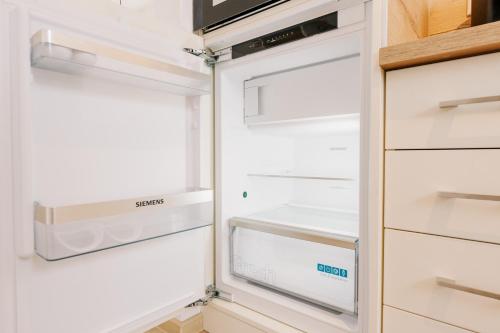 an empty refrigerator with its door open at Küsten Suite Grachten Suite 2 direkte Wasserlage, Terrasse, 76qm, Neubaugebiet in Greetsiel
