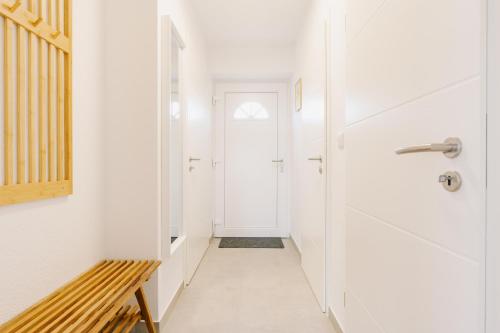 a hallway with a door and a bench at Küsten Suite Grachten Suite 2 direkte Wasserlage, Terrasse, 76qm, Neubaugebiet in Greetsiel