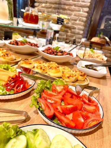 un tavolo con molti piatti di cibo sopra di Hotel Wine Time Tbilisi a Tbilisi City