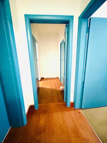 an empty hallway with blue doors and wooden floors at Executive Accommodation Bellville 2 in Cape Town