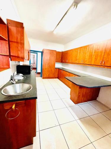 a kitchen with wooden cabinets and a sink at Executive Accommodation Bellville 2 in Cape Town