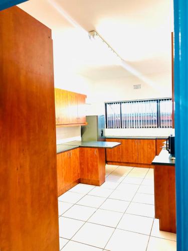 a large kitchen with wooden cabinets and a large window at Executive Accommodation Bellville 2 in Cape Town