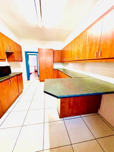 a kitchen with wooden cabinets and a black counter top at Executive Accommodation Bellville 2 in Cape Town