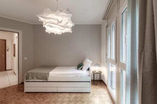 a bedroom with a bed and a chandelier at Pink Flat 2 by Quokka 360 - At the border of Switzerland in Chiasso