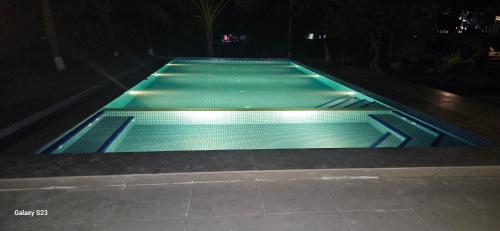 an empty swimming pool at night at Aqua Arina Holiday Farm House in Murud