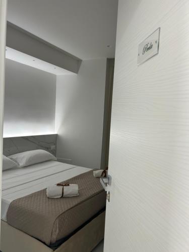 a bedroom with a bed and a door with towels on it at Emerald Rooms in Naples