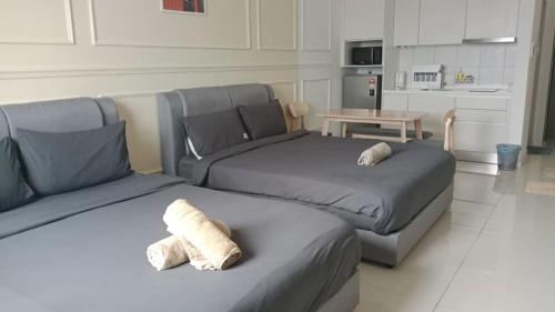 two beds in a room with a kitchen at Chambers Residence by Gloria Homes in Kuala Lumpur