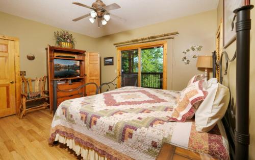 Un dormitorio con una cama y un ventilador de techo. en Riversong Retreat, en Pittman Center