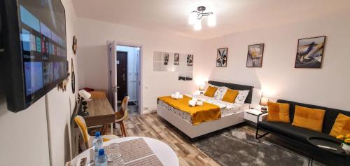 a room with a bed and a couch and a tv at The Yellow King - Luxurious Apartment in Bucharest