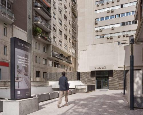 Un uomo che cammina per strada in una città di Limehome Madrid Calle de Juan Hurtado de Mendoza a Madrid