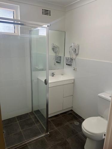 a bathroom with a shower and a toilet at Yass Motel in Yass