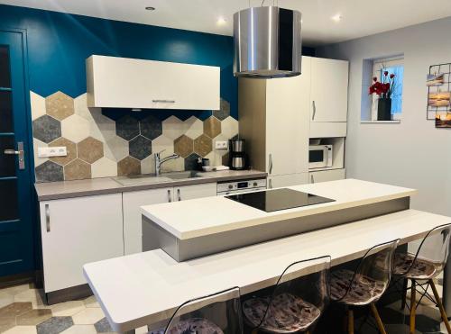 une cuisine avec des armoires blanches et un évier dans l'établissement Les Tournaisiens, Cottage à 2 pas de Wimereux, à Wimille