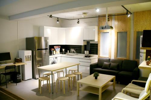 een keuken en een woonkamer met een bank en een tafel bij Seoul Dalbit Dongdaemun Guesthouse in Seoul