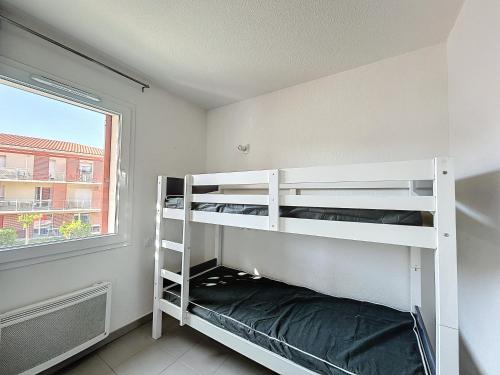 une chambre avec deux lits superposés et une fenêtre dans l'établissement 3309-T3 dans une résidence avec piscine, à Argelès-sur-Mer