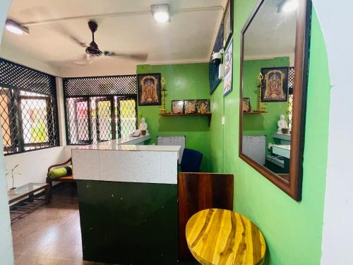 a green room with a table and a mirror at EESTEE Canal in Colombo