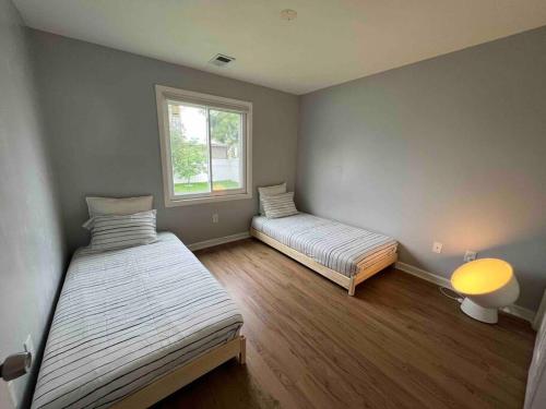 una camera da letto con due letti e una finestra di Beach House 2Car parking Beach Subway City JFK USB a Edgemere