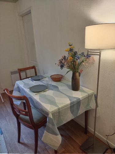 a table with a vase of flowers on it at Studio privatif DATCHA in Saint-Germain-en-Laye