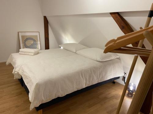 a white bed in a room with a ladder at 3 BR Duplex in Wiedikon in Zurich