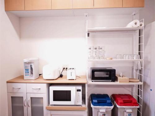 a kitchen with a counter with microwaves and appliances at EIDOUYADO鶴見橋QB-one 10min難波 3min全生活便利 in Osaka