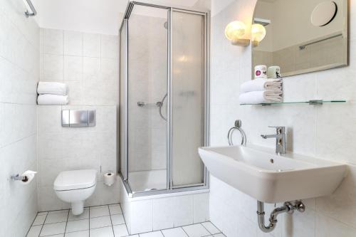 a bathroom with a shower and a sink and a toilet at Hotel Esplanade Dortmund in Dortmund