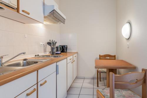 a small kitchen with a sink and a table at Hotel Esplanade Dortmund in Dortmund