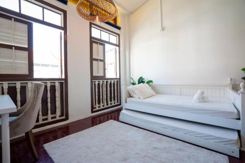 a room with a bed and a table and windows at The Bibik at 8 Clarke -NEW Entire #Unesco #HeritageHome in George Town