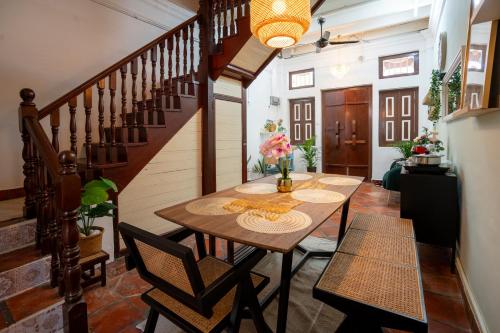 a dining room with a table and a staircase at The Bibik at 8 Clarke -NEW Entire #Unesco #HeritageHome in George Town